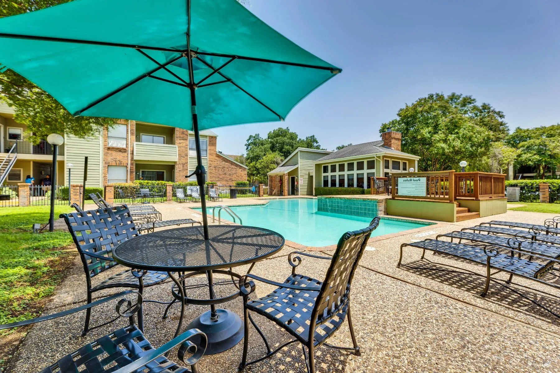Table with umbrella and chairs with view of swimming pool