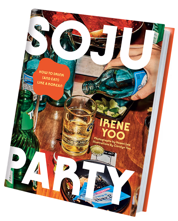 Cover of the book 'Soju Party' showing a hand pouring soju into a glass surrounded by snacks and bottles on a wooden table.