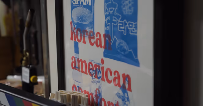Framed artwork featuring illustrations of Spam canned meat and Korean instant noodles with the text 'korean american comfort' in red letters.