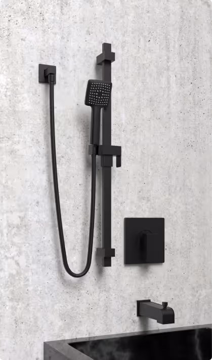 Modern matte black wall-mounted showerhead and faucet set installed on a concrete wall above a black bathtub.