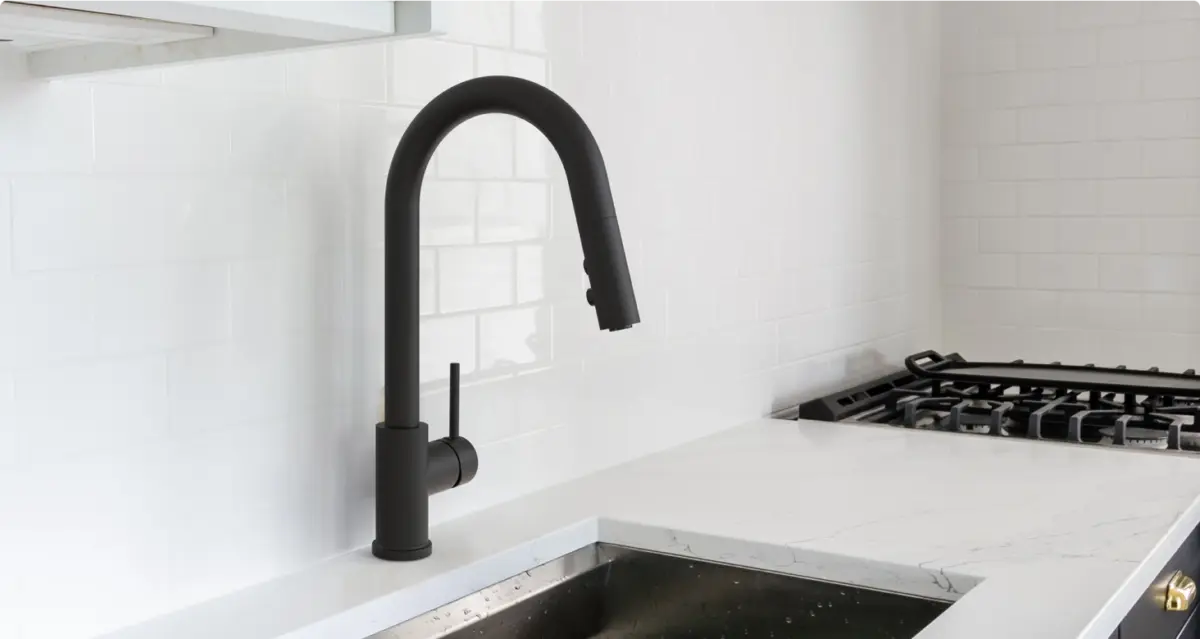 Modern kitchen sink with a matte black arched faucet and white subway tile backsplash.