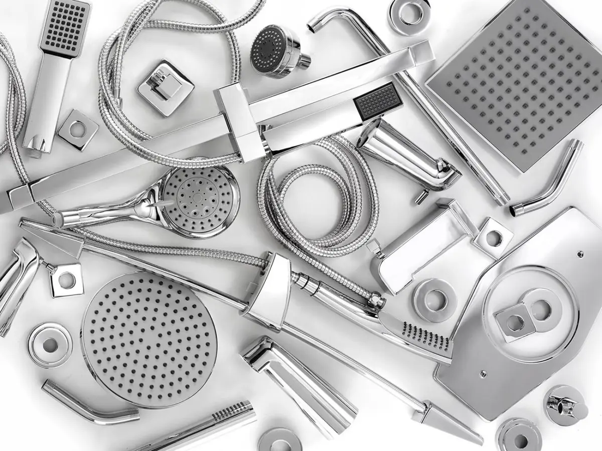 Various chrome showerheads, hoses, and bathroom faucet accessories arranged on a white surface.