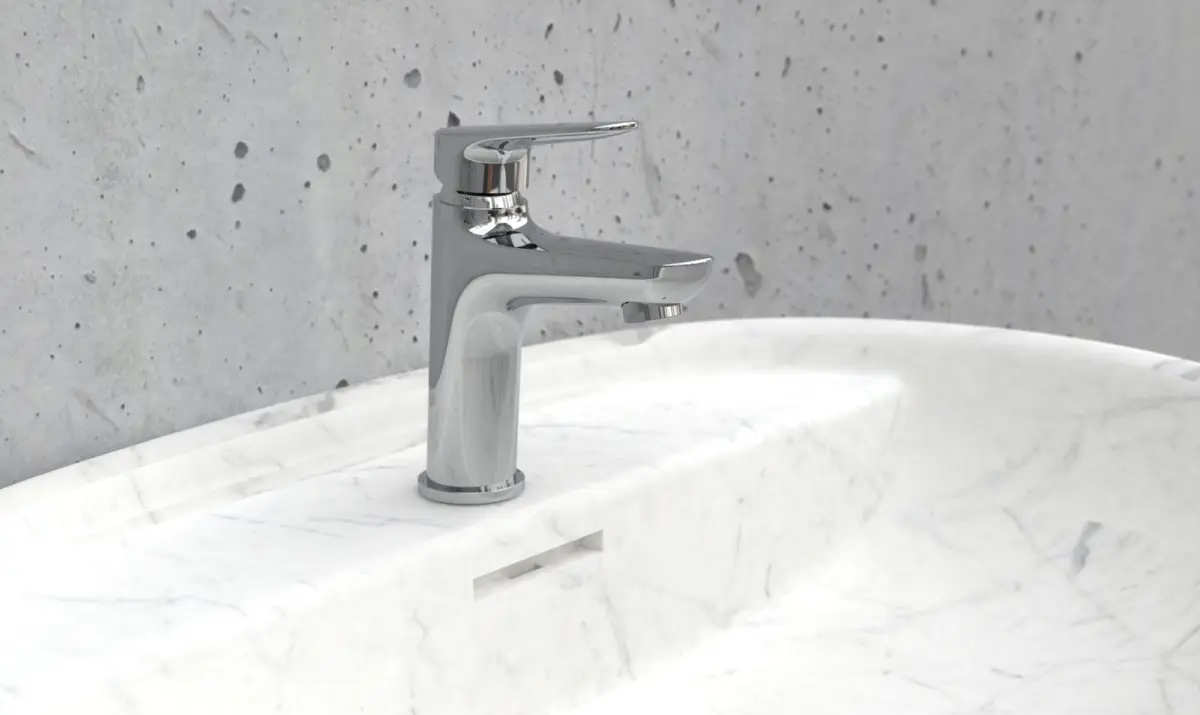 Modern chrome faucet mounted on a white marble sink with a gray speckled wall in the background.
