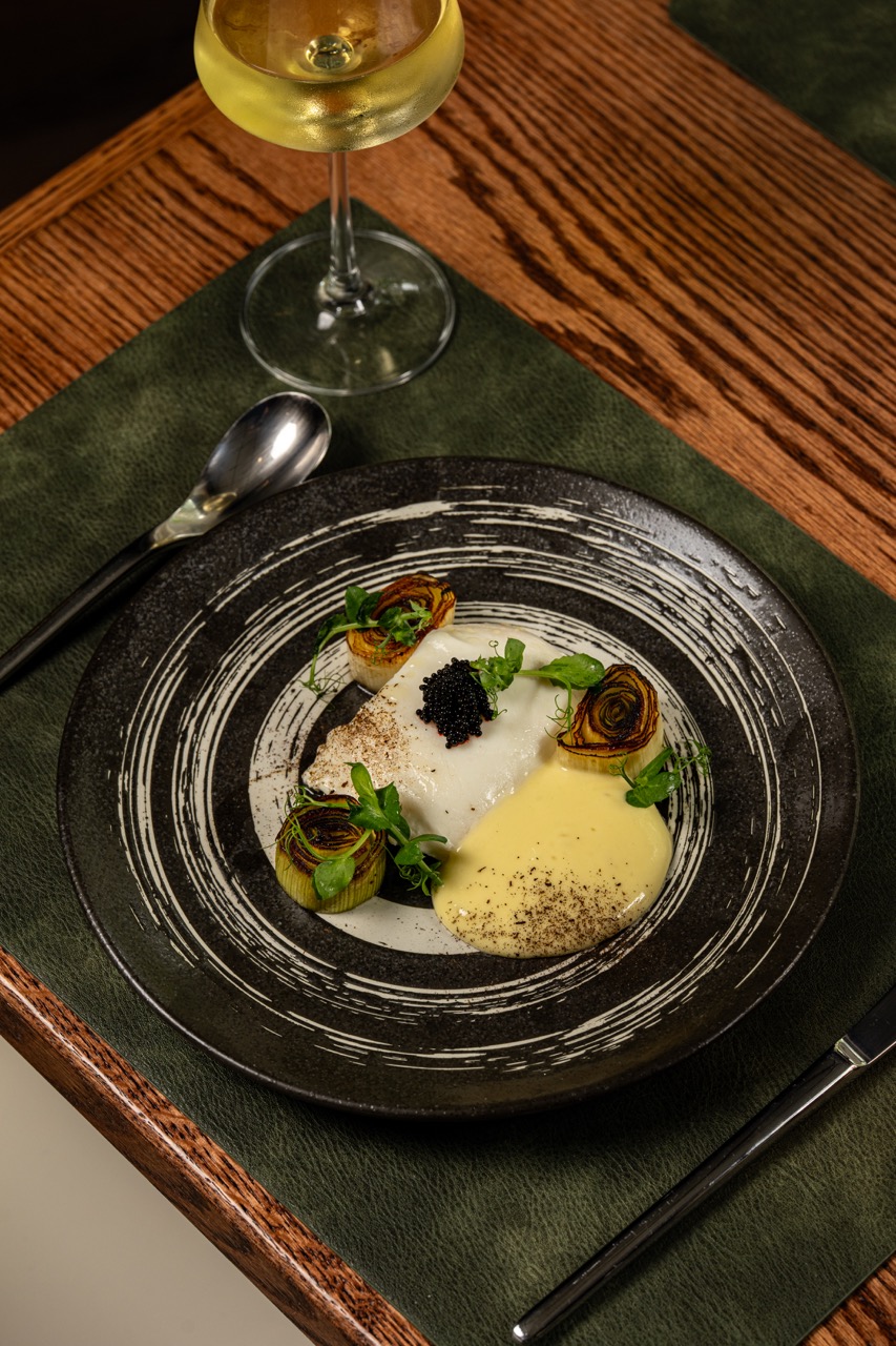 Black and white spiral plate with halibut, leek, white chocolate buerre blanc