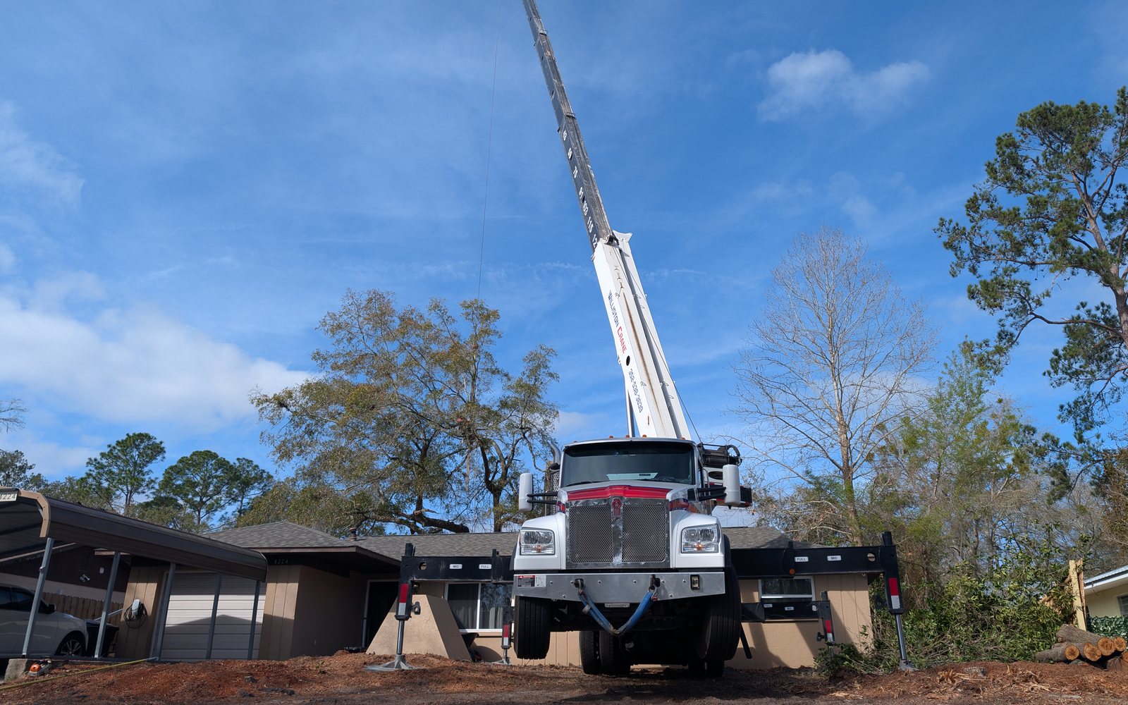 Crane truck set up for complex residential tree removal in Gainesville Florida