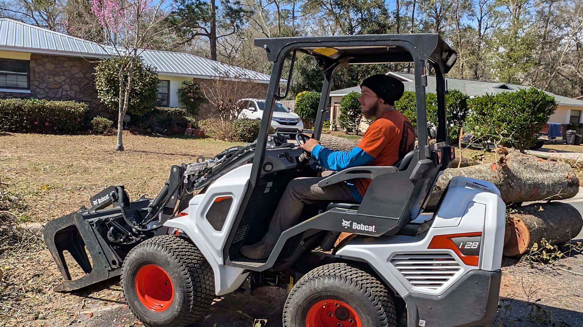 Priority Tree Removal mini loader staged to protect a driveway and lawn