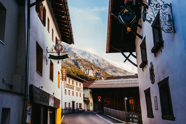 A narrow street with a mountain in the background