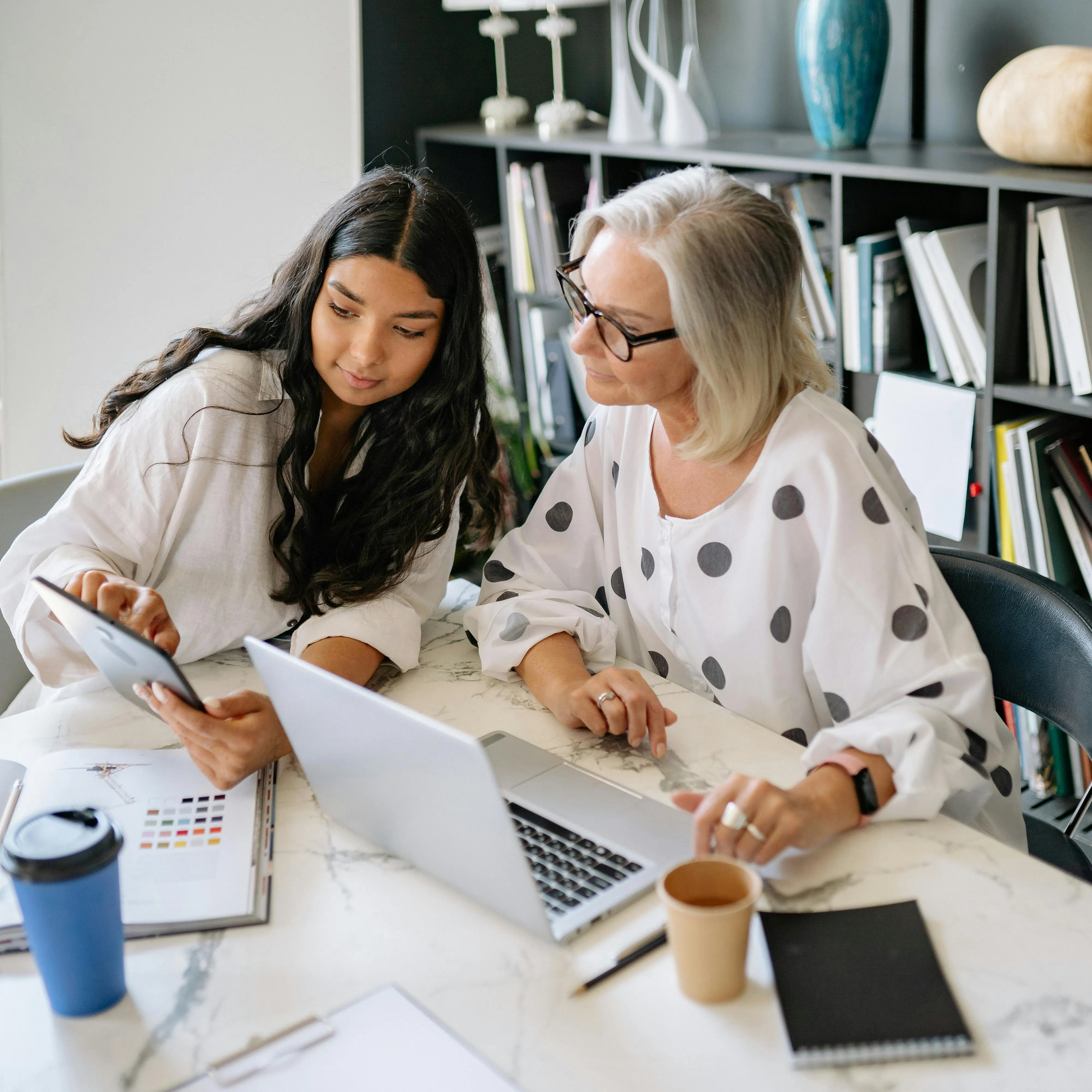 a woman and a young woman looking at a laptop