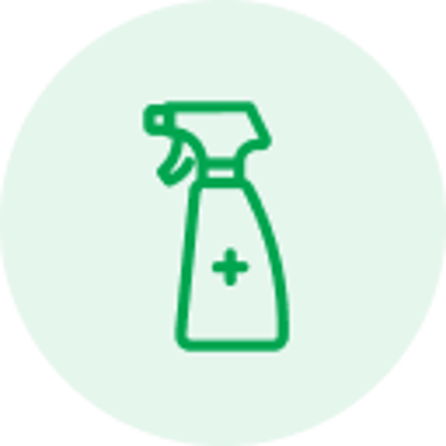 Green line icon of a spray bottle with a plus sign inside, on a light circular background.