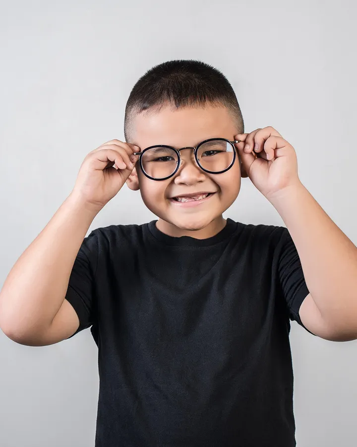 young-boy-trying-on-new-glasses-at-local-optician