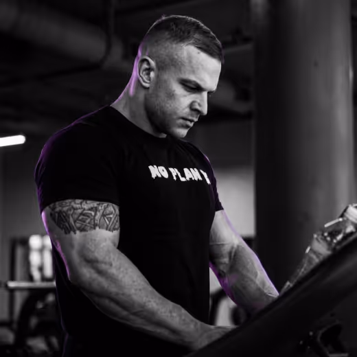 Muscular athlete concentrating on strength training using gym equipment