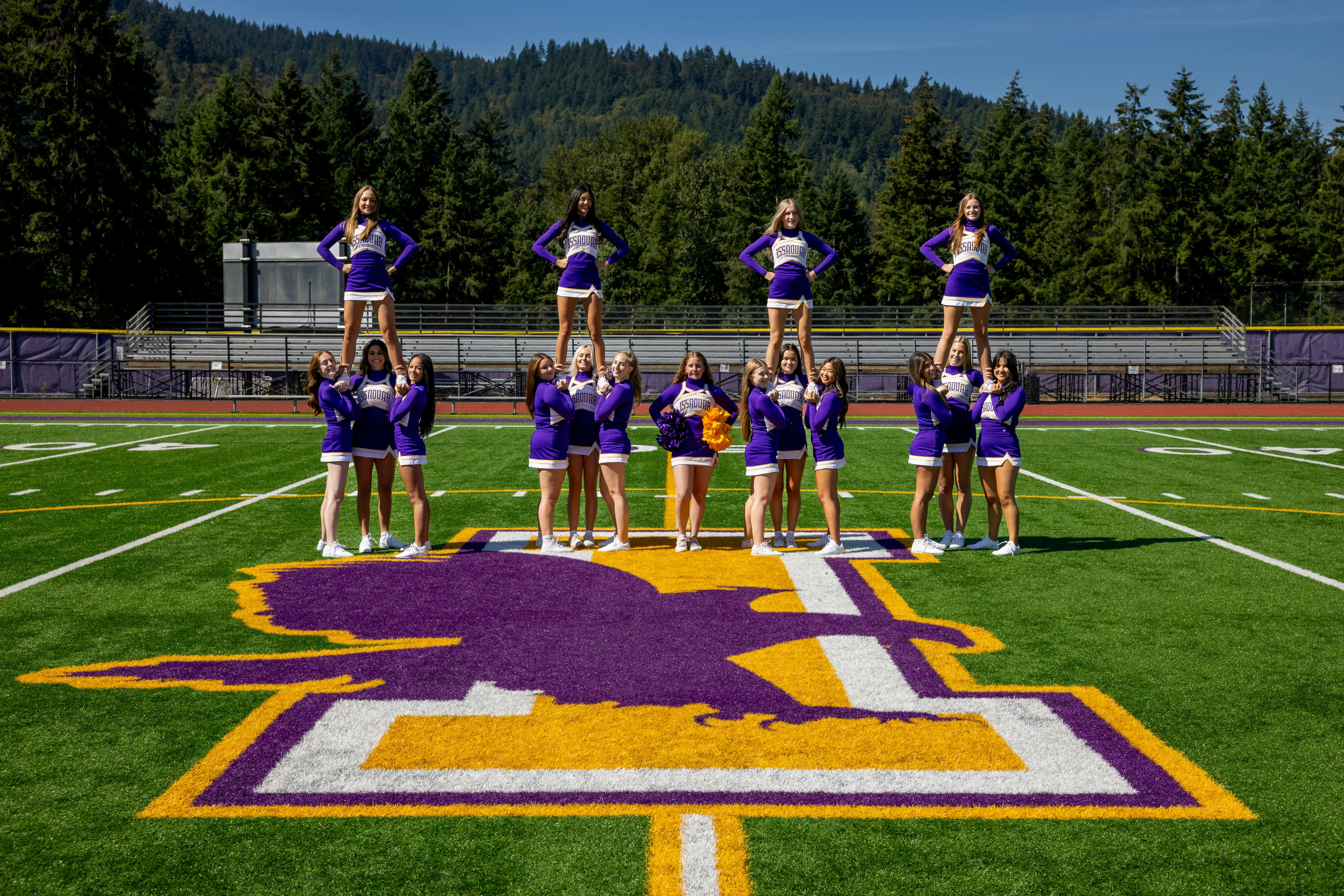 image of issaquah, wa cheerleaders outside on the football field doing stunting.