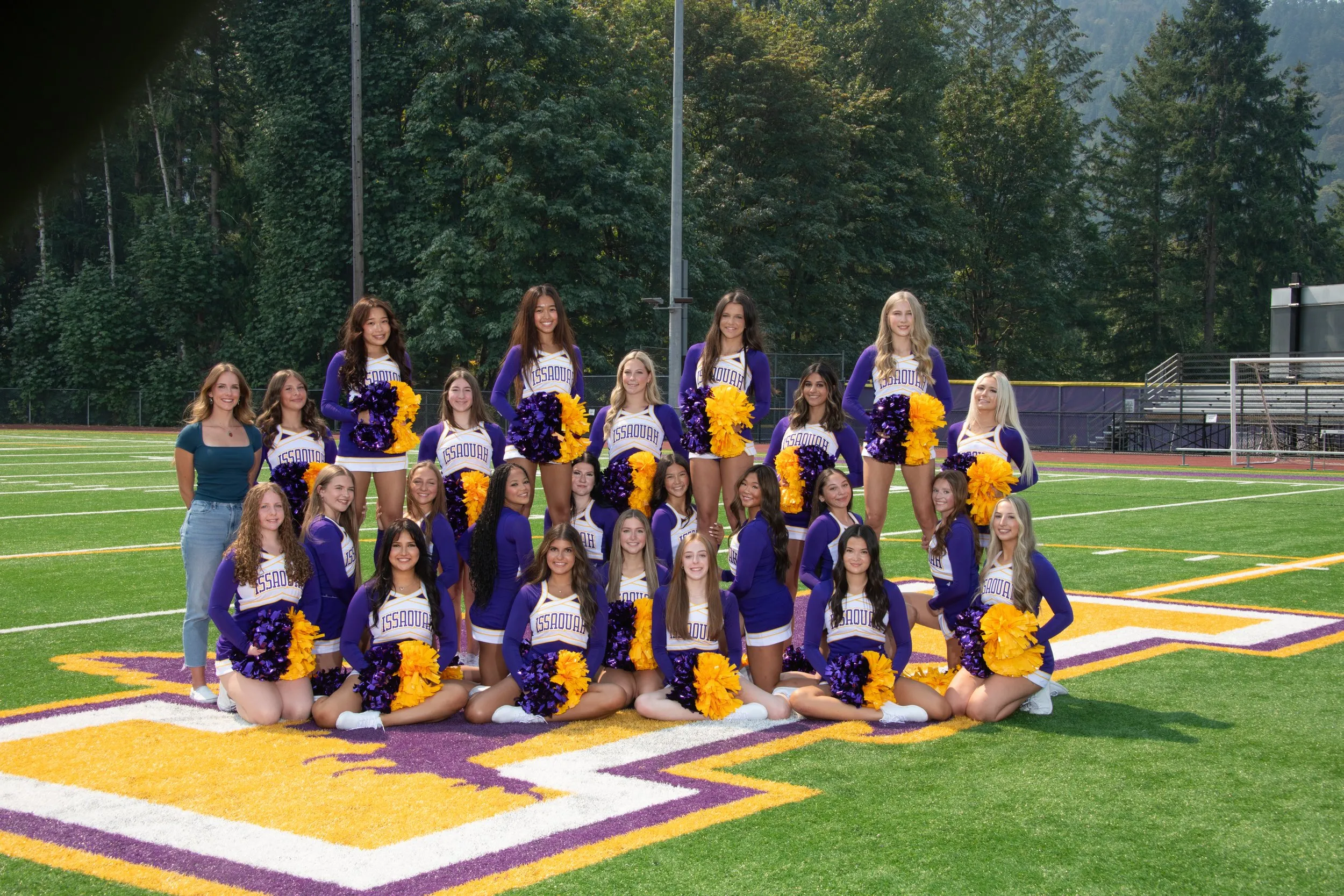 2026 Issaquah high Varsity cheer team. Cheerleaders outside in the Issaquah stadium on a sunny day