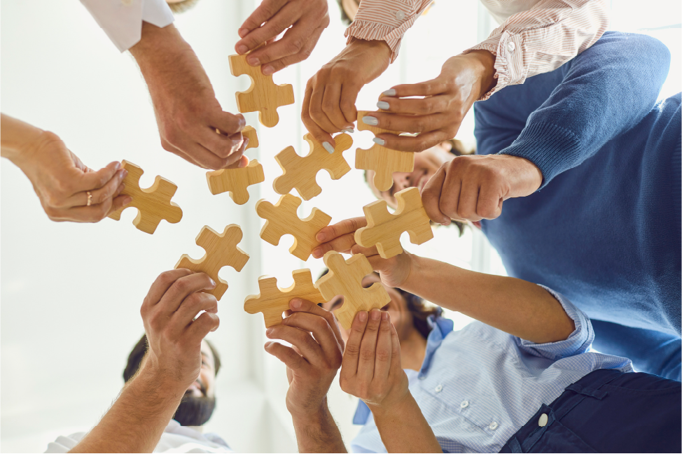 Team joining puzzle pieces to symbolize collaboration
