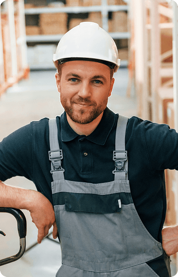 Вантажник в робочому одязі на складі з полицями.