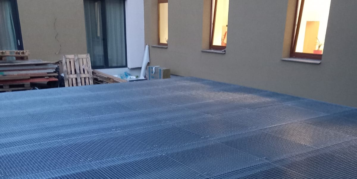Žárově zinkovaná ocelová roštová terasa během montáže