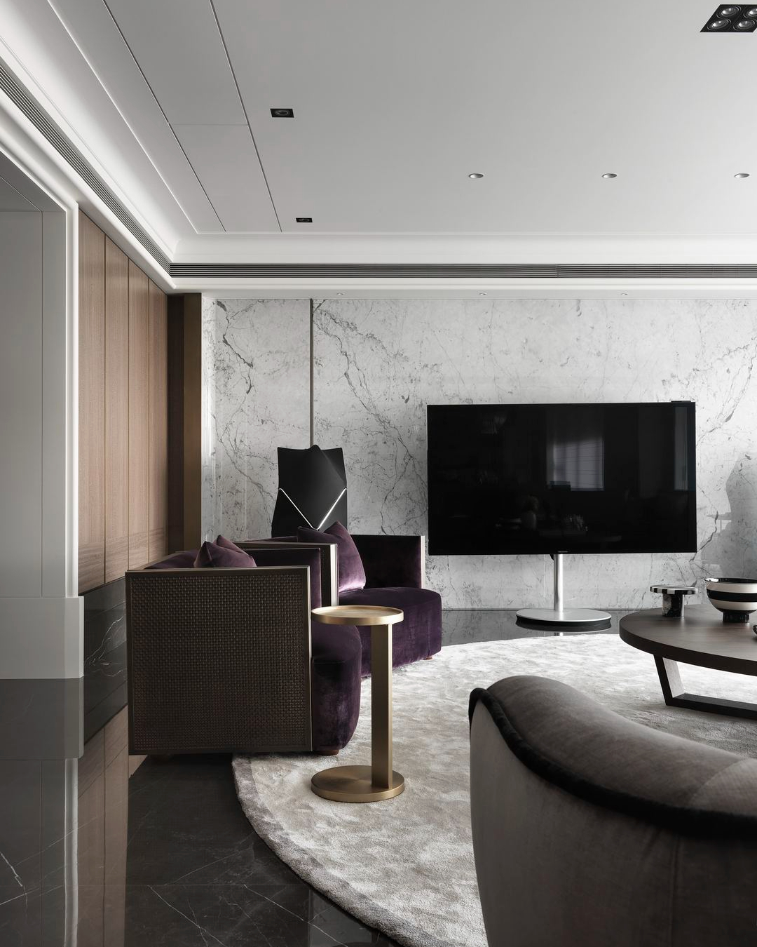 珥本設計｜寶輝秋紅谷客廳電視牆：白色 Carrara 大理石牆面配 Bang & Olufsen 黑色立式喇叭，搭配 PROMEMORIA 紫色絨布扶手椅與黃銅圓邊几。