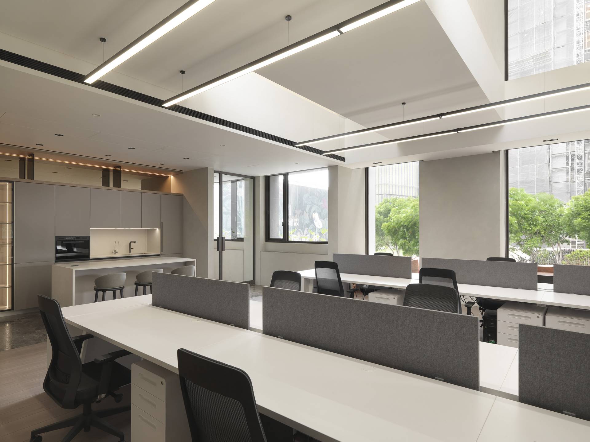 珥本設計|帝璟建設辦公室二樓工作區:Alea Office 系統辦公桌沿窗一字排開,落地窗引入城市綠意與自然採光,超耐磨木地板延伸至端景,構築均質的專注氛圍