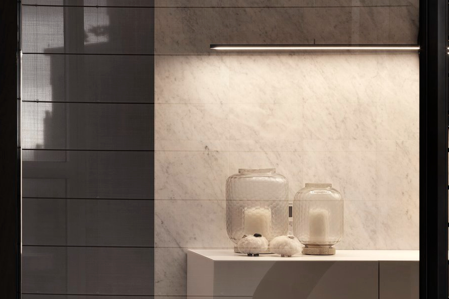 珥本設計｜BOFFI HOME II 材質細節景：SALVATORI白色雲霧大理石背牆與青銅編織網屏風並列，LED線性燈以暖光洗過石紋，浮雕玻璃器皿與白色岩石造型擺件靜物陳列