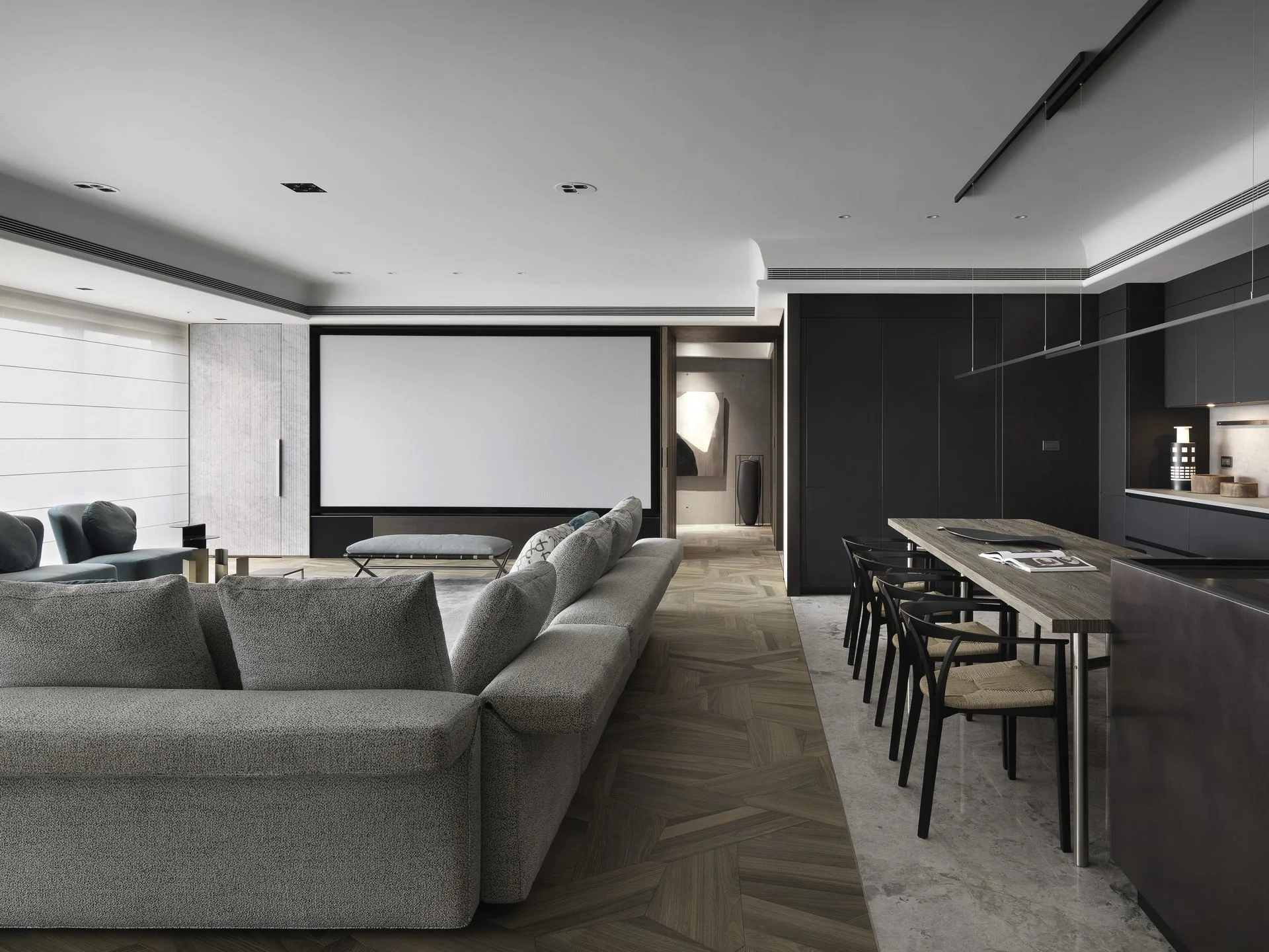 珥本設計｜丽格 III 住宅公領域主敘事：MINOTTI 灰色 L 形沙發與 Barcelona Chair 長凳並置，投影布幕嵌於中景牆體，右側 BOFFI 黑色整面廚具搭風化橡木長桌與 Wishbone 黑椅，玉檀香木地板貫穿全景