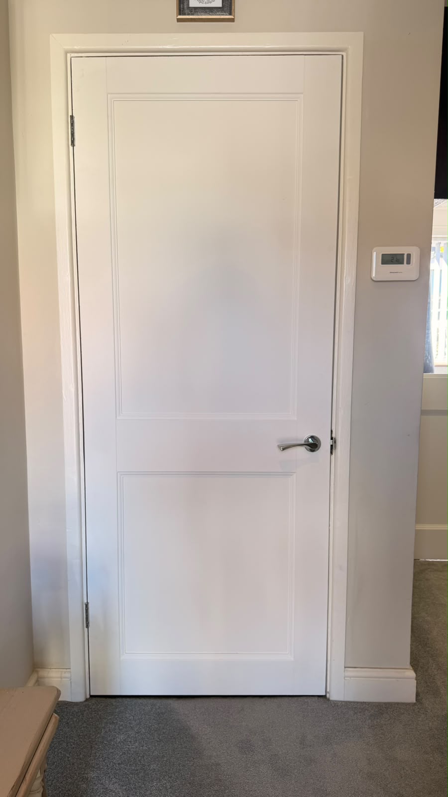 Primed Elmbridge panel door fitted beside a thermostat in Farnborough