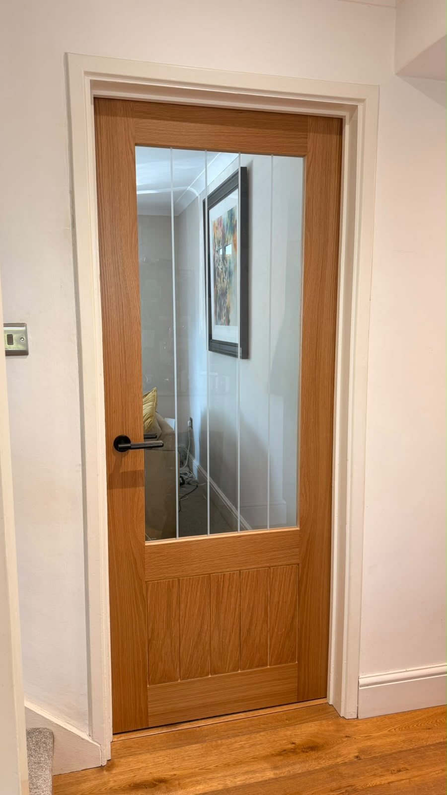 Fully finished oak cottage glazed door with a black lever handle fitted in Bordon