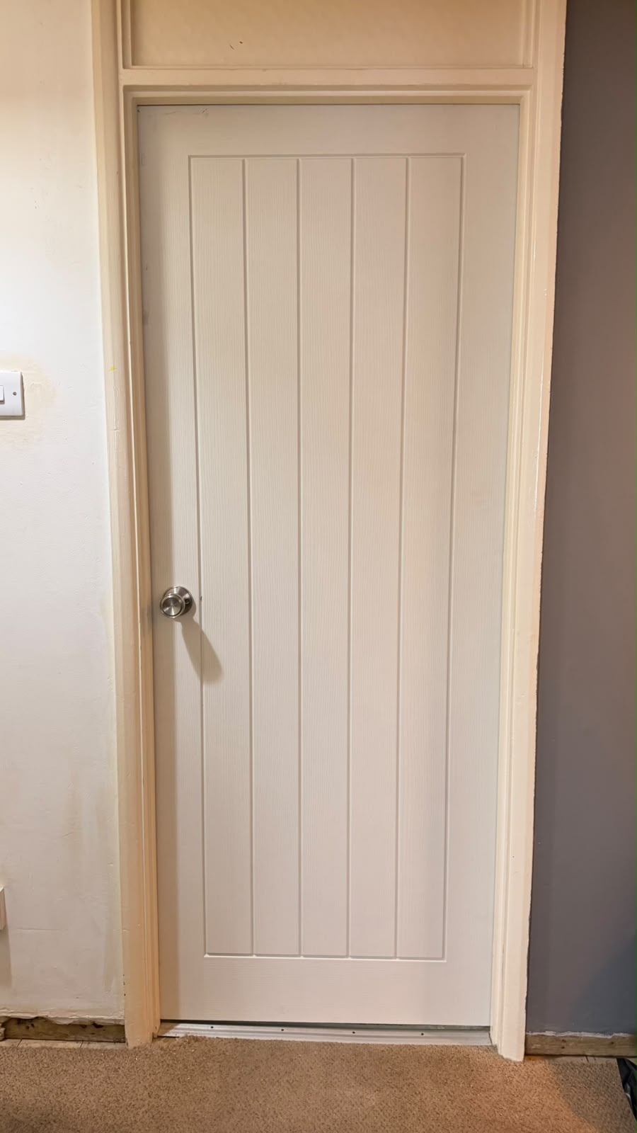 White cottage internal door with vertical detailing and a silver round doorknob fitted in Yateley