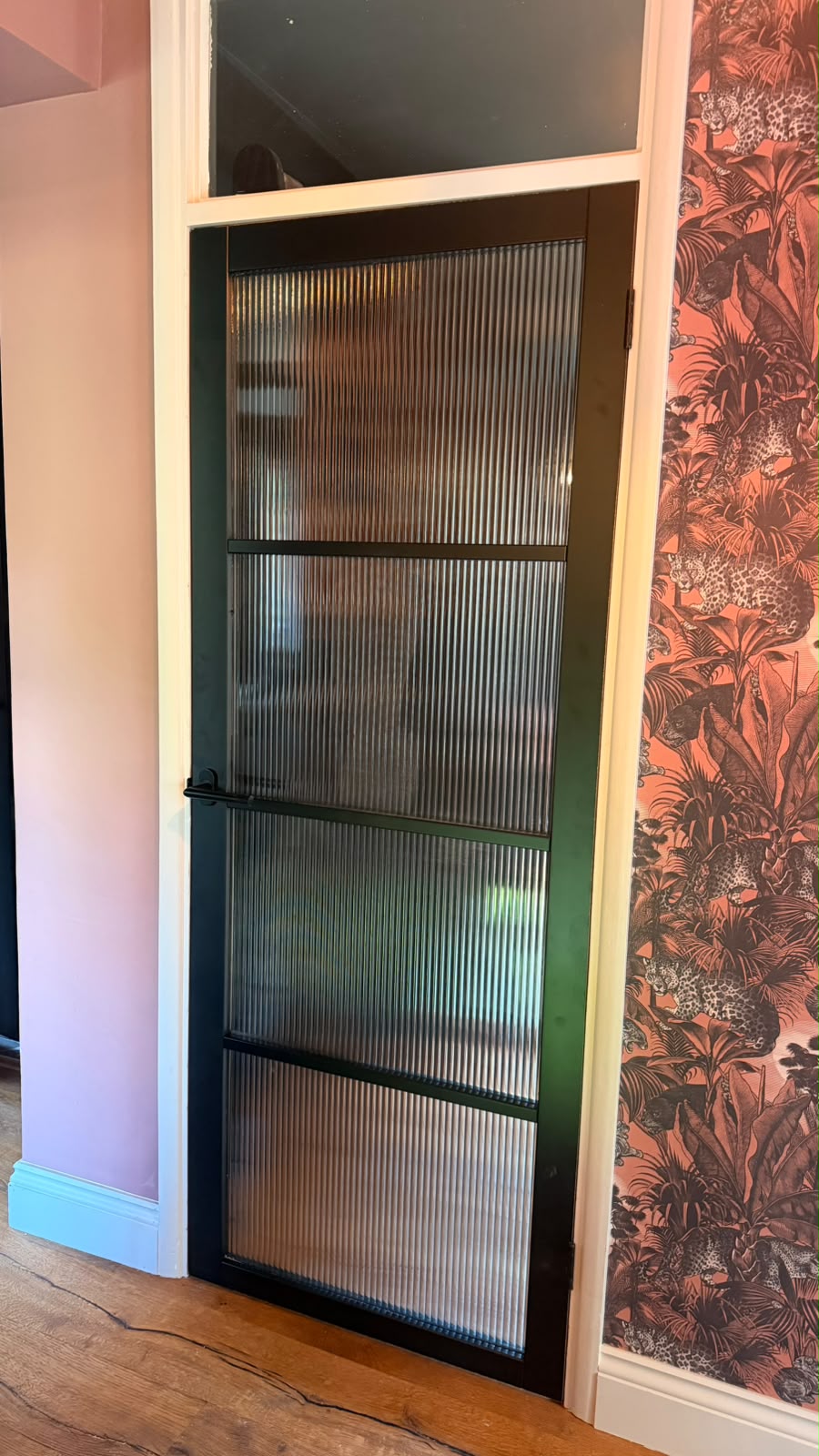 Jet black four-light reeded glass Studio internal door with a black lever handle fitted in Haslemere