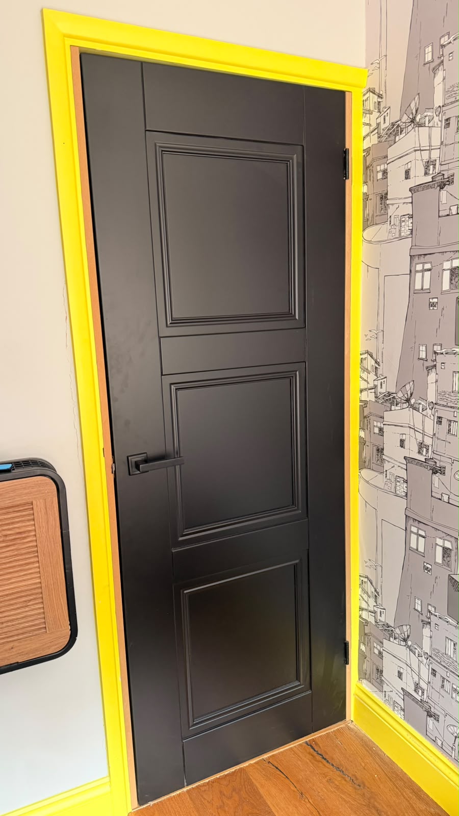 Black Elegance Ripley internal door with moulded panels and a black lever handle in a yellow frame in Haslemere
