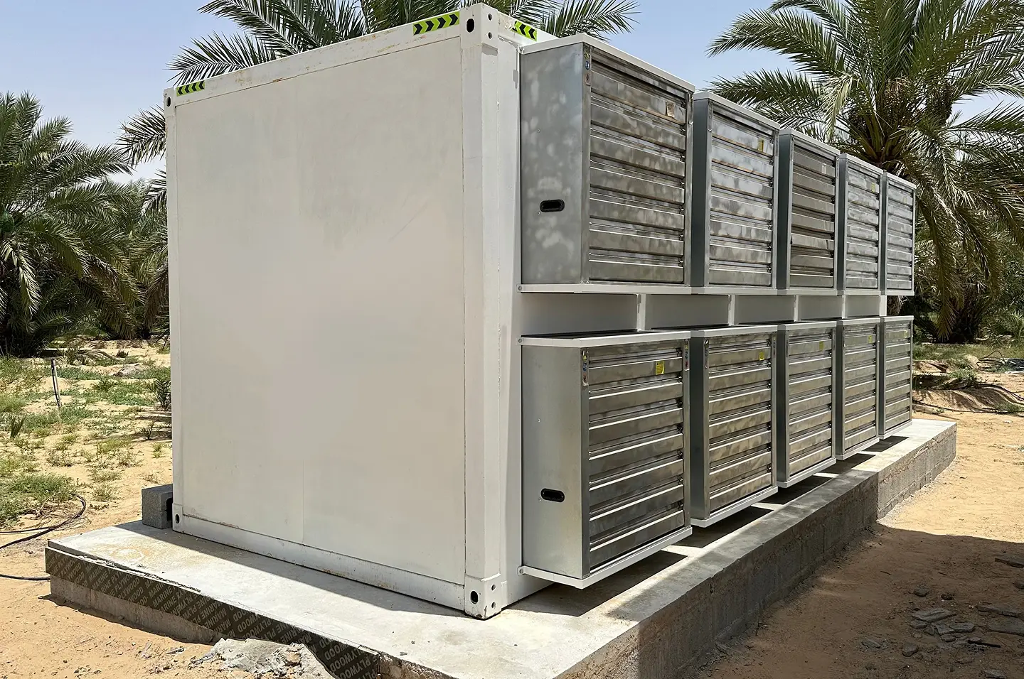 Bitcoin mining containers installed at Pure Mining facility in UAE with palm trees.