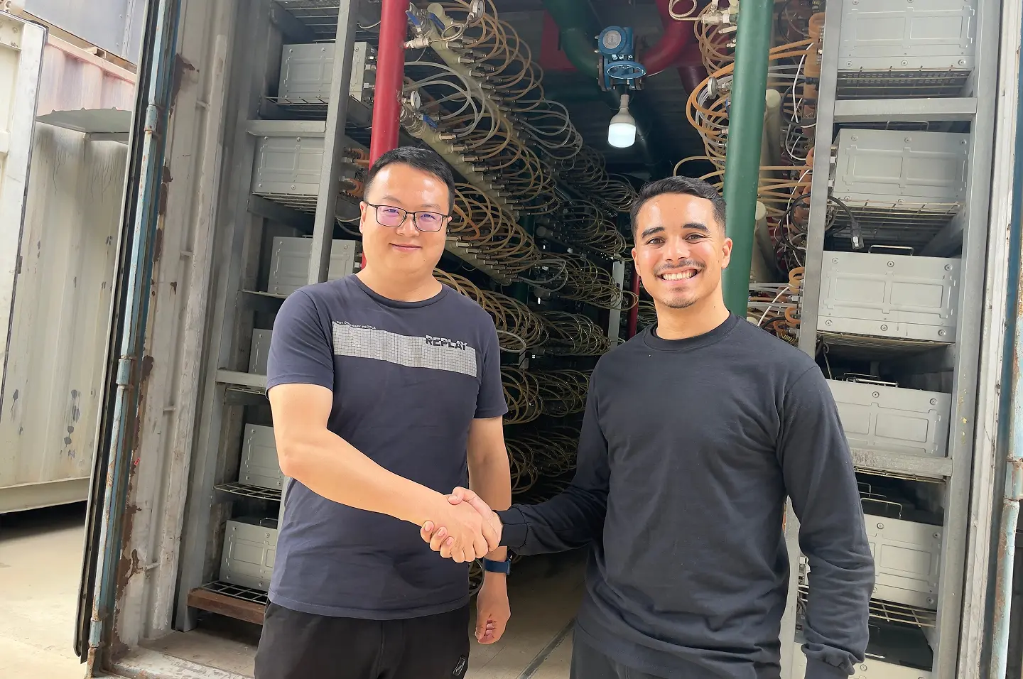 Pure Mining team members shaking hands at Angola mining facility.