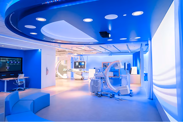 Modern medical imaging room with advanced scanning equipment and blue ambient lighting.