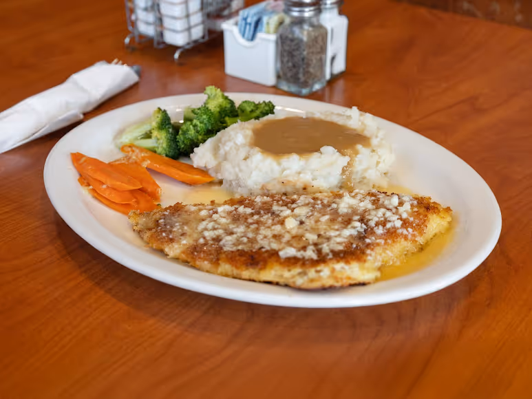 A plate of food with a piece of meat and vegetables.