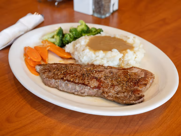 A plate of food with a steak and vegetables.
