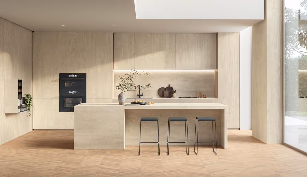 Moderne keuken met licht houten kasten, een kookeiland met drie zwarte krukken en een grote glazen schuifdeur naar buiten.