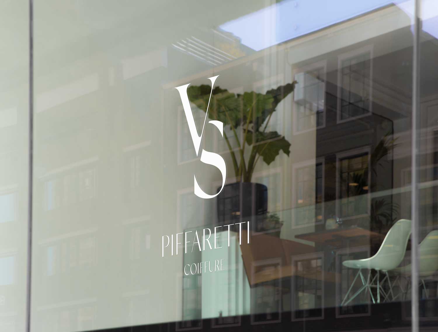 VS Piffaretti Coiffure Logo auf Glasscheibe eines Friseursalons, elegantes weisses Monogramm-Logo mit Serif-Schrift