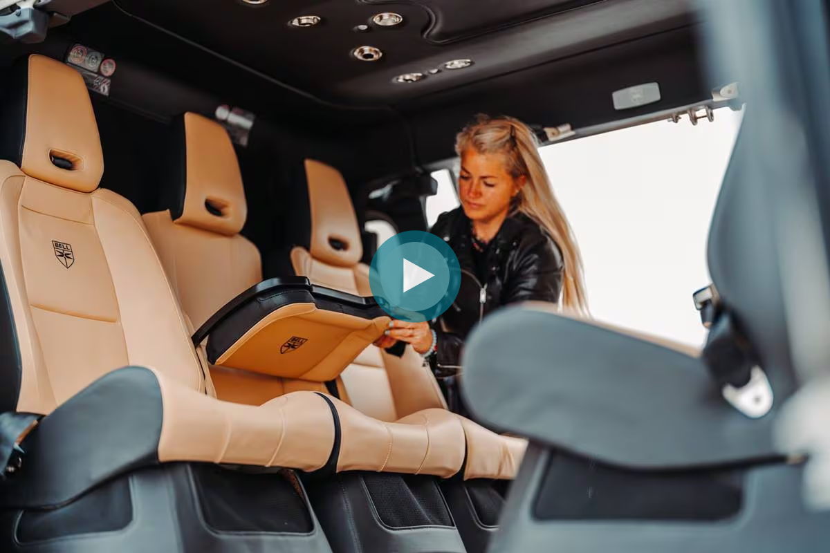 A woman in a black jacket is adjusting a foldable table in a luxury vehicle's interior.
