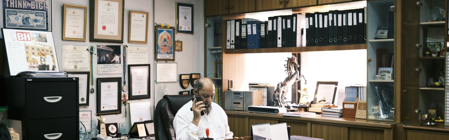 Man taking a phone call while working in busy office.