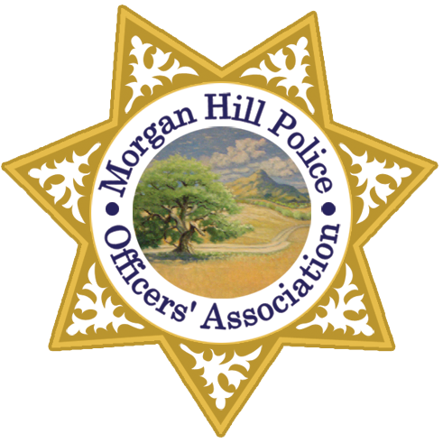 Gold seven-pointed star badge with white decorative patterns and a central circle showing a tree, a field, and a mountain, encircled by the text 'Morgan Hill Police Officers' Association'.