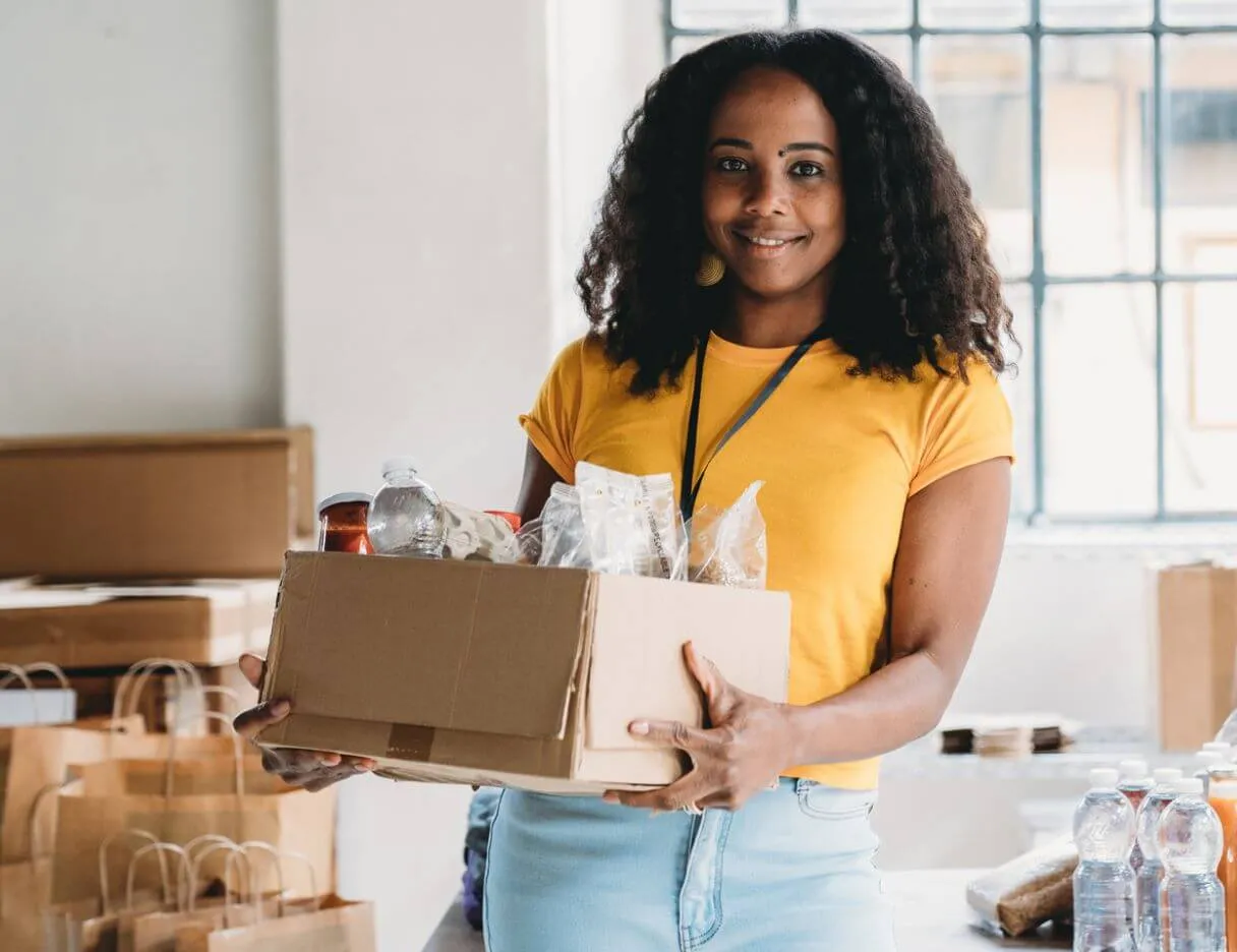 a woman holding a box full of food