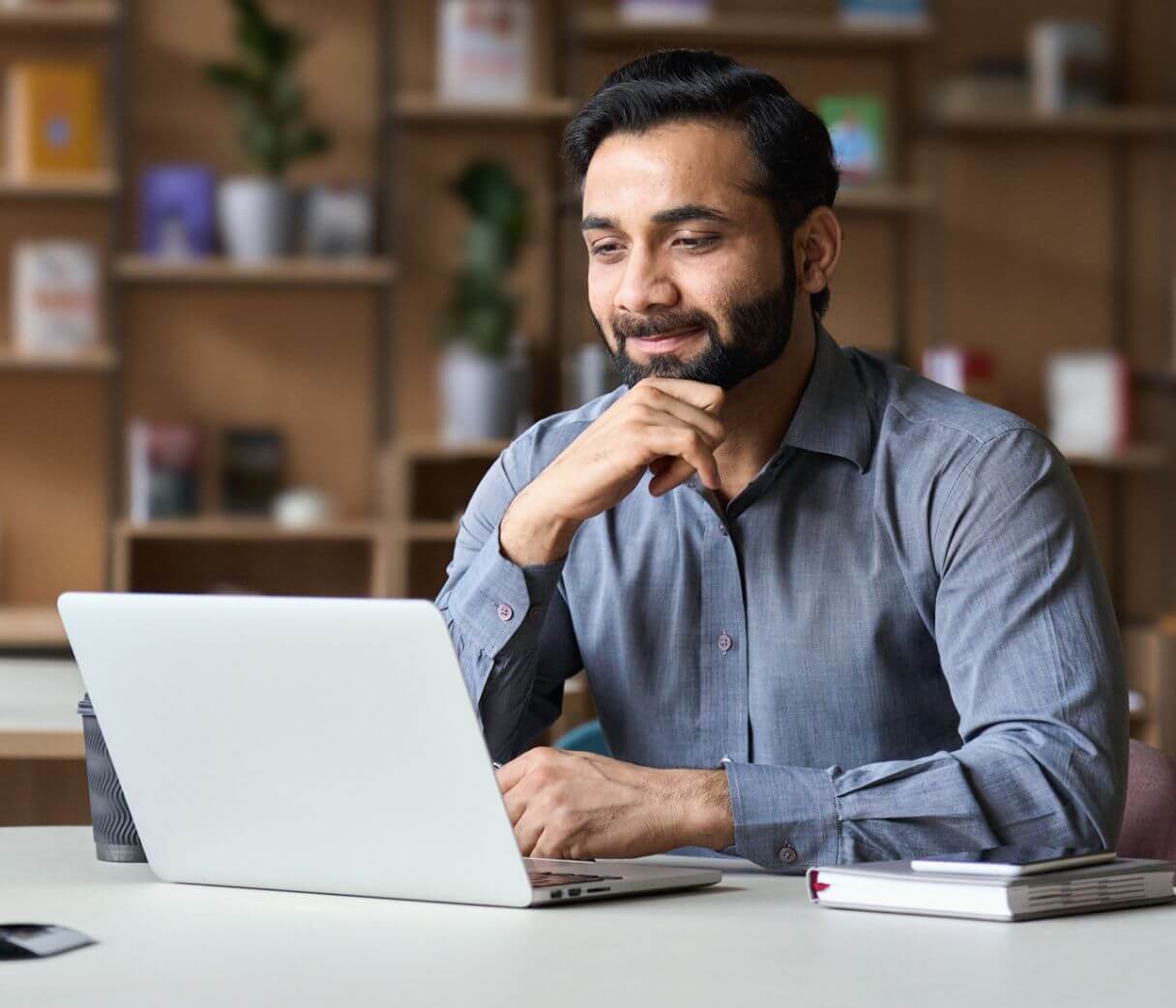a man sitting in front of a laptop computer paying a bill