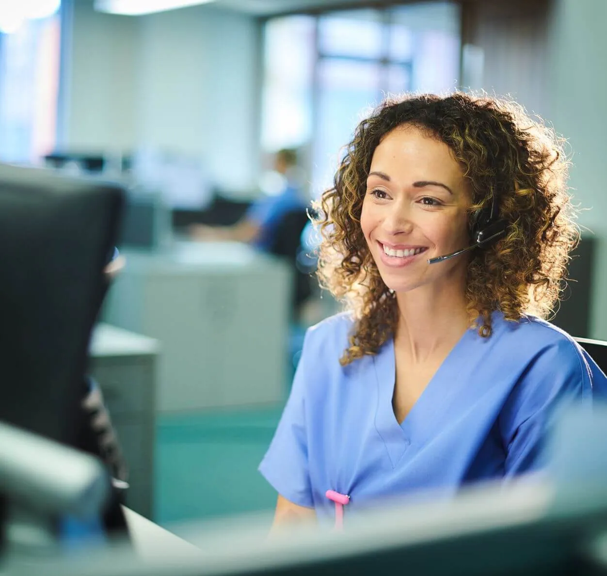 a woman with a headset sitting in front of a computer