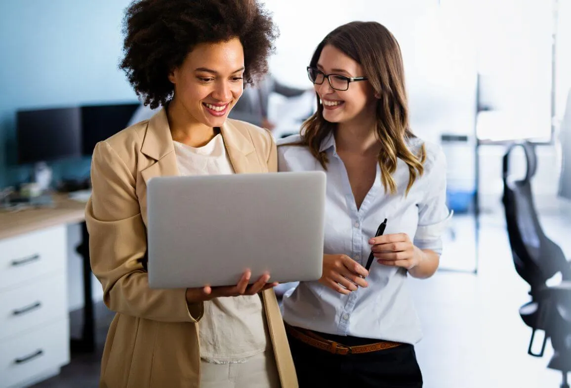 two women are looking at a laptop screen