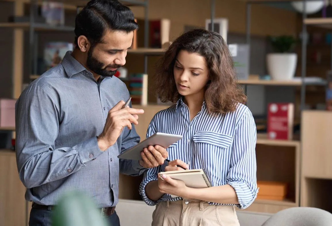 a man and a woman looking at a tablet