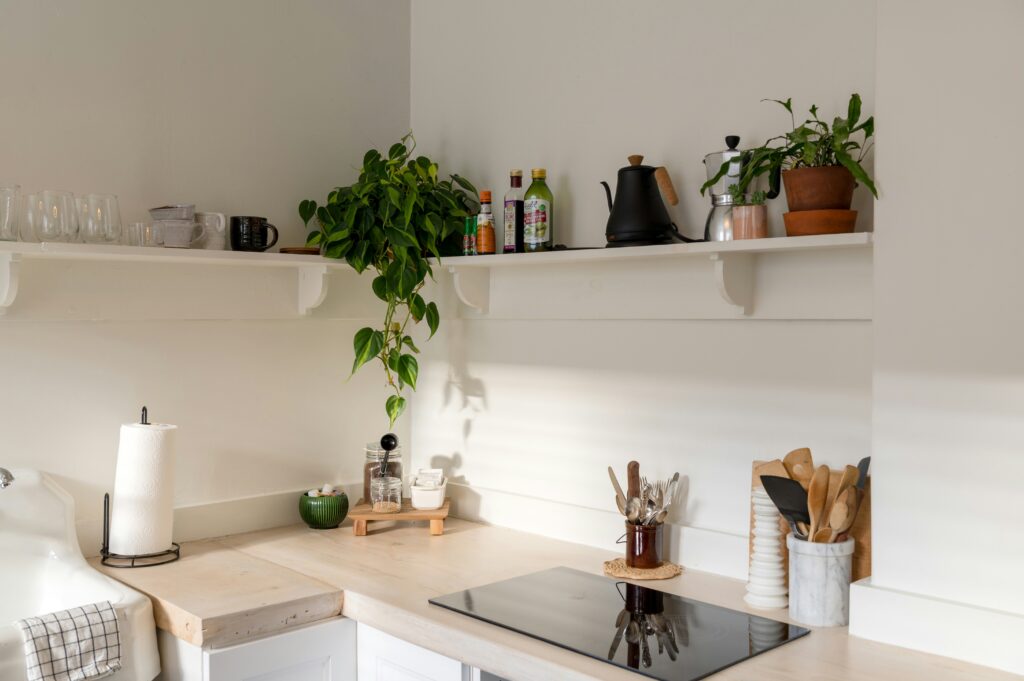 Image of a white kitchen. The kitchen is stocked with wooden spoons and other reusable kitchen supplies. 
