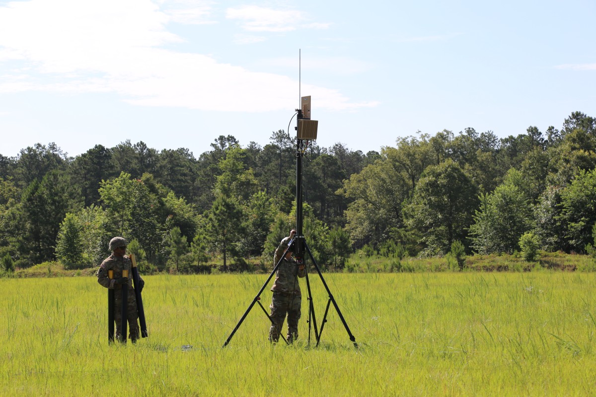 U.S. Army soldiers deploying a BlueSky Mast 350 Lift Series tripod with a TRILOS terminal in a field