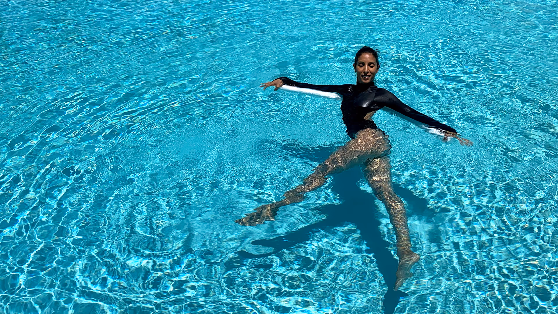 Woman doing a low-impact pool workout for full-body strength and joint-friendly movement.
