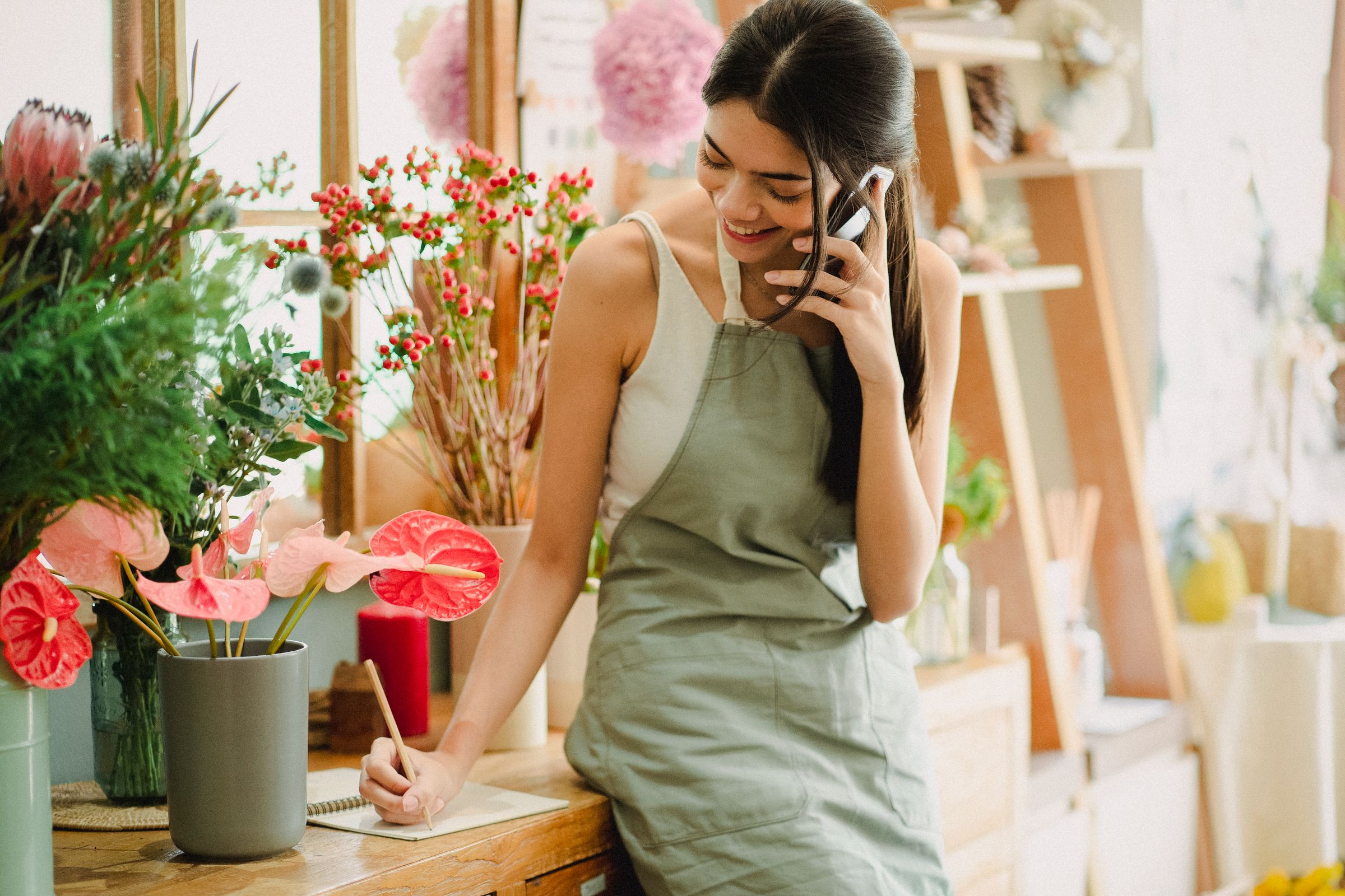 Small business owner on the phone at her shop counter