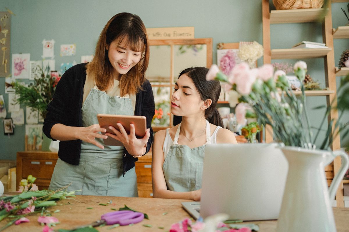 Two small business owners reviewing an account together on a tablet