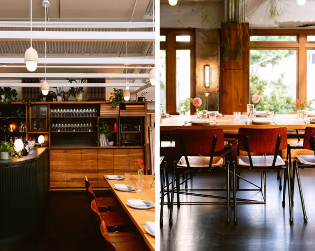 Cozy restaurant interior with wooden tables and chairs, set with plates, glasses, and flowers, illuminated by ceiling lights.